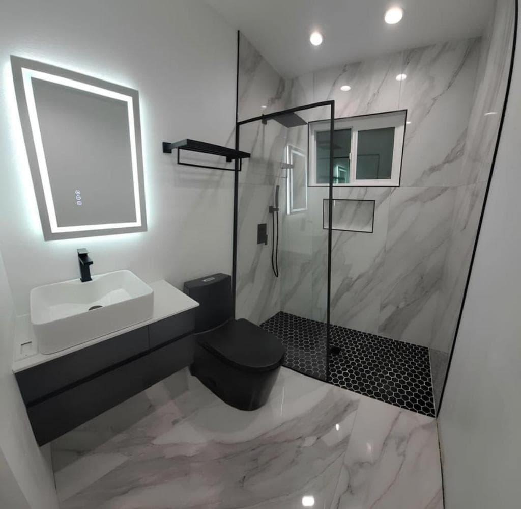 Ultra-modern bathroom with matte black toilet, designer sink and marble tiles